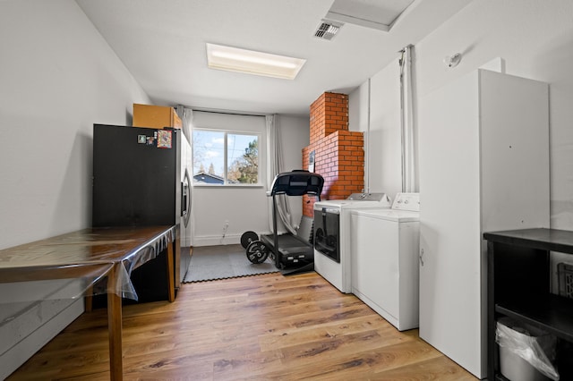 washroom with light wood-type flooring, visible vents, independent washer and dryer, attic access, and laundry area