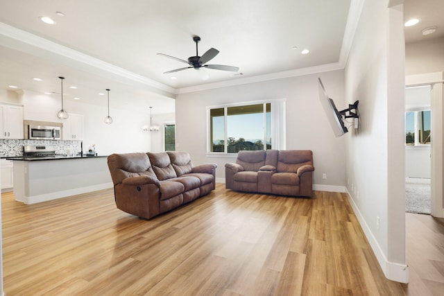 living room with light wood-type flooring, recessed lighting, crown molding, baseboards, and ceiling fan