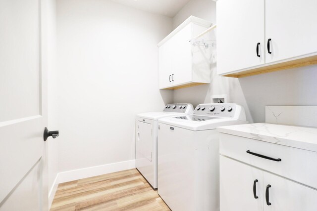 clothes washing area featuring baseboards, light wood-type flooring, cabinet space, and independent washer and dryer