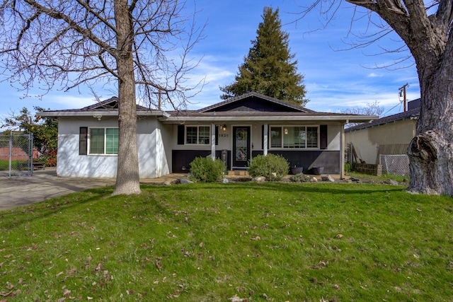 single story home with a gate, stucco siding, a front lawn, and fence