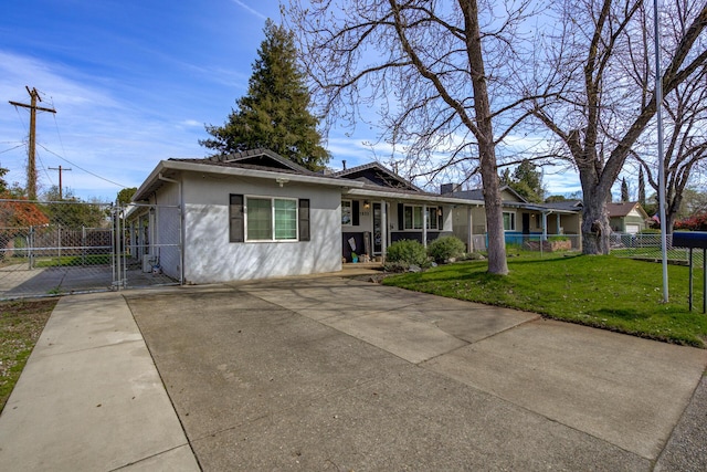 ranch-style home featuring a front yard, a gate, fence, driveway, and stucco siding