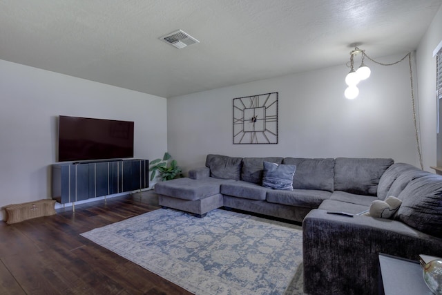 living area featuring visible vents, a textured ceiling, and wood finished floors