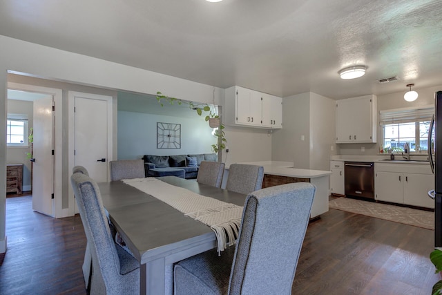 dining area with visible vents, plenty of natural light, and dark wood-type flooring