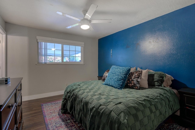 bedroom featuring baseboards, a ceiling fan, and dark wood-style flooring