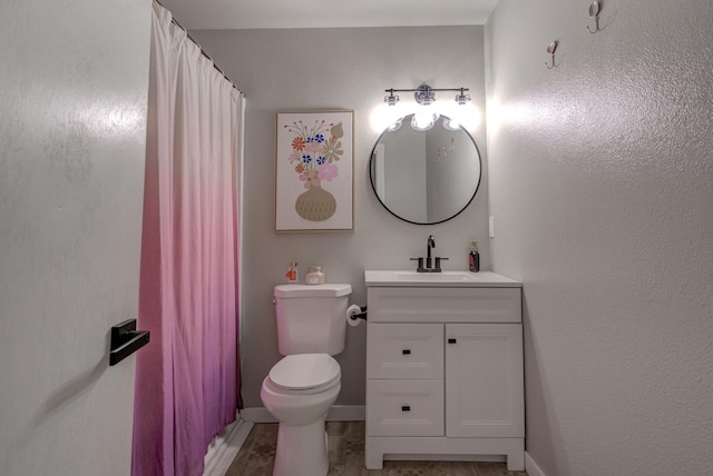 bathroom with toilet, vanity, a shower with shower curtain, and baseboards