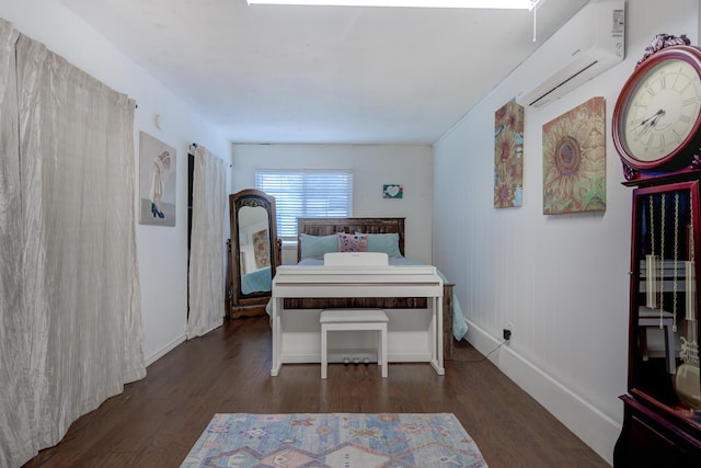 bedroom featuring a wall mounted air conditioner, baseboards, and wood finished floors