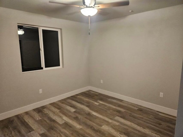 spare room with dark wood finished floors, ceiling fan, and baseboards