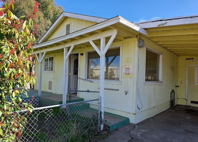 view of property exterior with a carport and fence