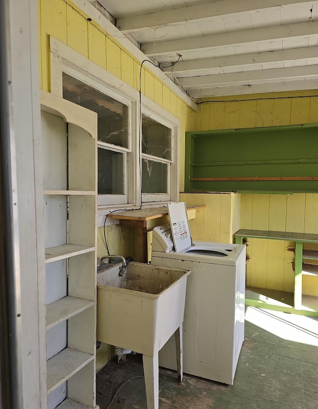 laundry area featuring a sink, laundry area, wood walls, and washing machine and clothes dryer