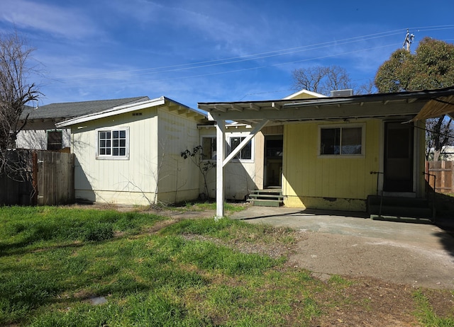 rear view of property with crawl space, fence, and entry steps