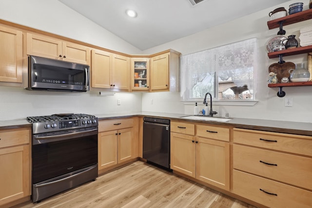 kitchen with light brown cabinets, light wood-type flooring, lofted ceiling, stainless steel appliances, and a sink