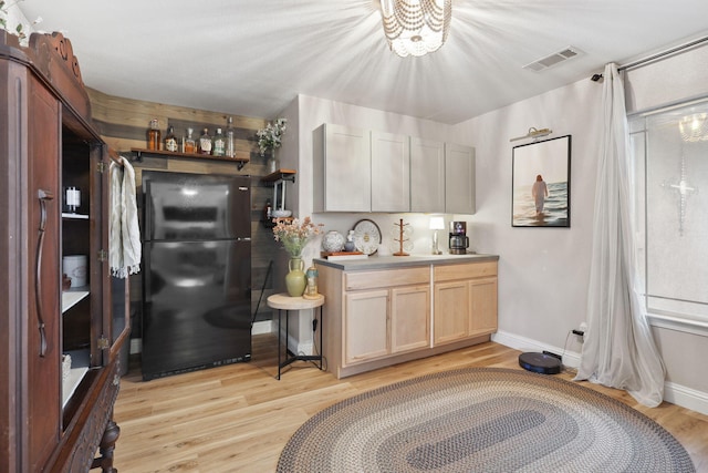 kitchen with visible vents, light wood finished floors, baseboards, and freestanding refrigerator