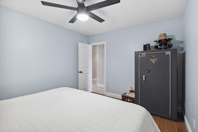 bedroom featuring baseboards, light wood-style floors, and a ceiling fan