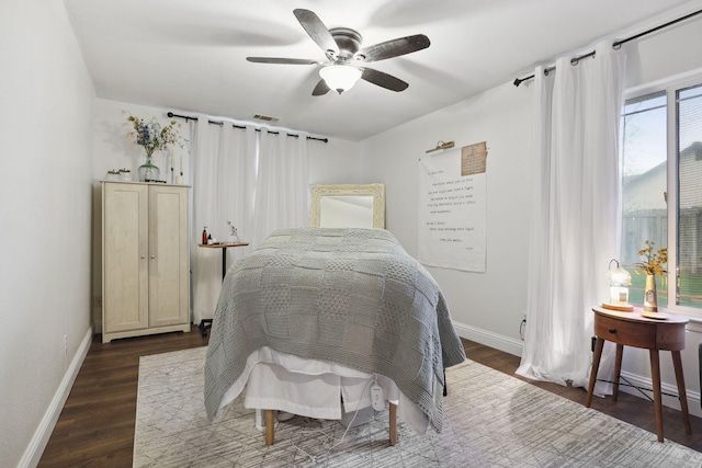 bedroom featuring a ceiling fan, wood finished floors, visible vents, and baseboards