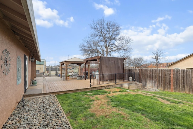 view of yard featuring a deck, a gazebo, and a fenced backyard