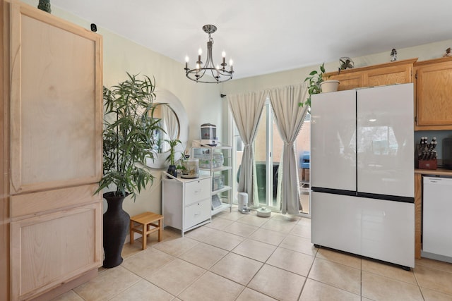 kitchen featuring white appliances, pendant lighting, light tile patterned floors, and a chandelier