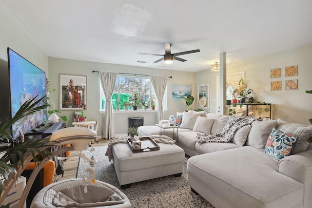 living room with visible vents, a ceiling fan, and wood finished floors