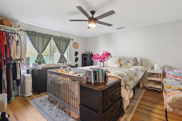 bedroom featuring visible vents, a ceiling fan, and light wood finished floors