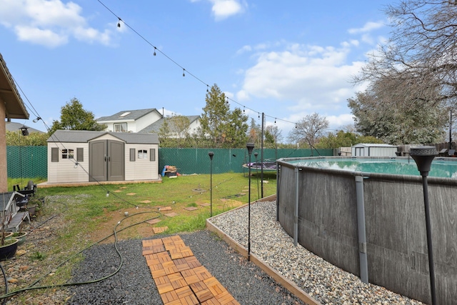 view of yard with a fenced in pool, a storage shed, and a fenced backyard