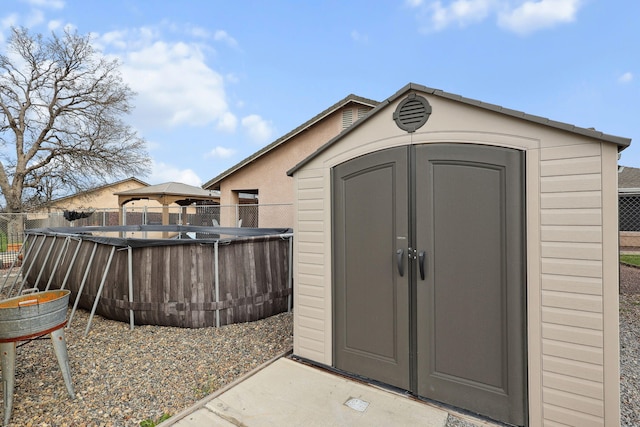 view of shed with fence and a fenced in pool