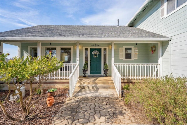 doorway to property with covered porch and roof with shingles