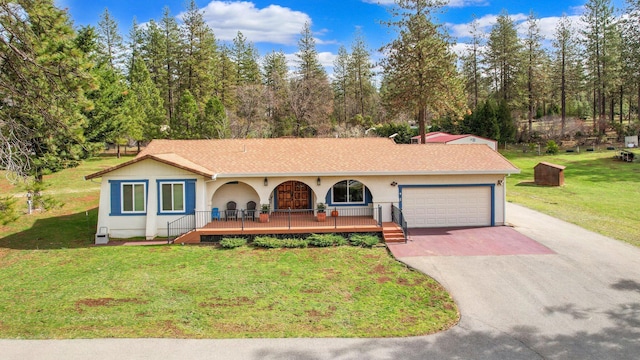 ranch-style home featuring a porch, concrete driveway, a front yard, stucco siding, and a garage