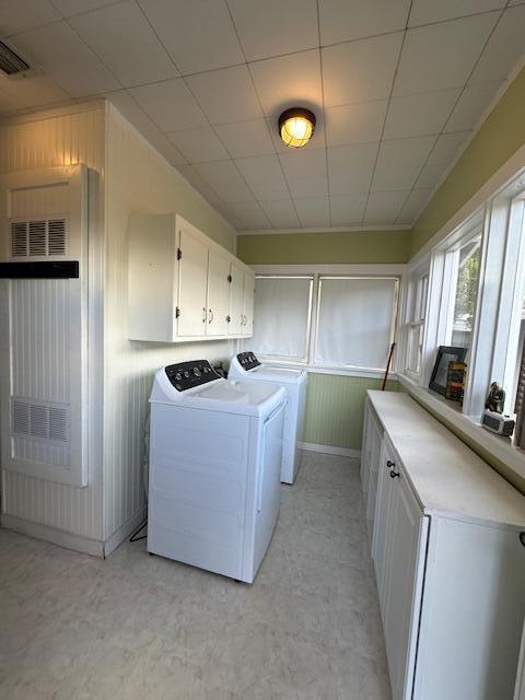 laundry room featuring washer and dryer, cabinet space, visible vents, and light floors