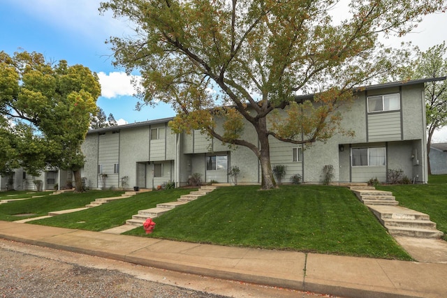 multi unit property featuring a front lawn and stucco siding