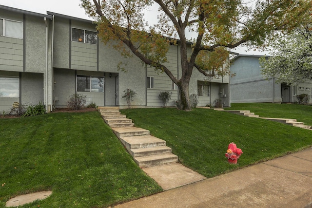 view of property with stucco siding and a front yard