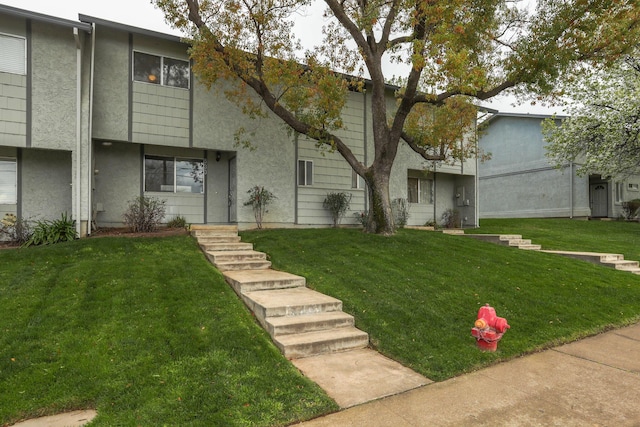 townhome / multi-family property featuring stucco siding and a front yard