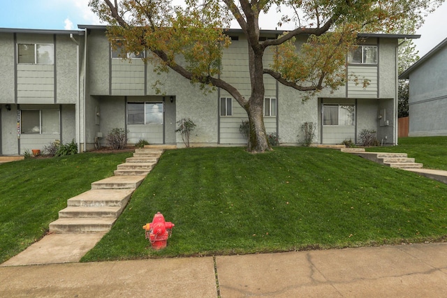 multi unit property featuring stucco siding and a front yard