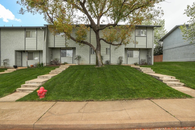 view of front of home featuring stucco siding and a front lawn