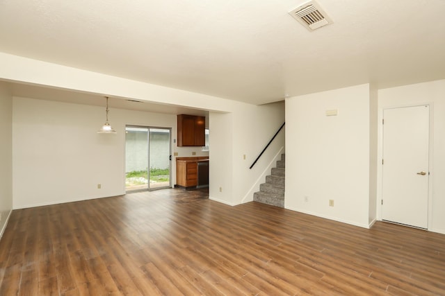 unfurnished living room featuring visible vents, baseboards, dark wood finished floors, and stairs