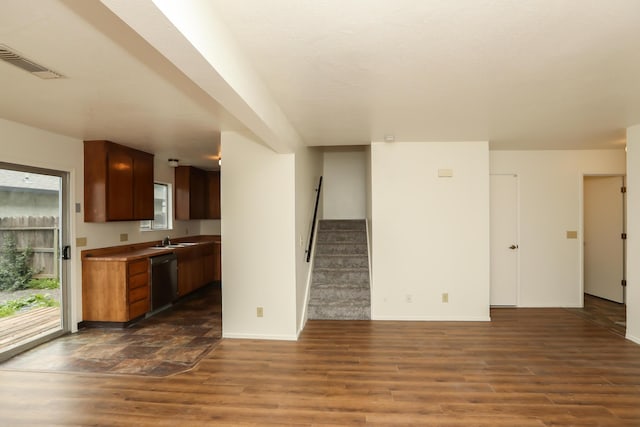 kitchen featuring a sink, visible vents, dishwasher, and dark wood-style flooring