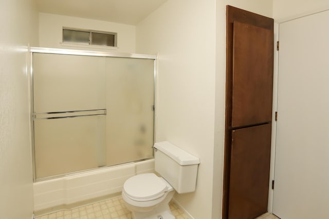 bathroom with tile patterned floors, enclosed tub / shower combo, and toilet