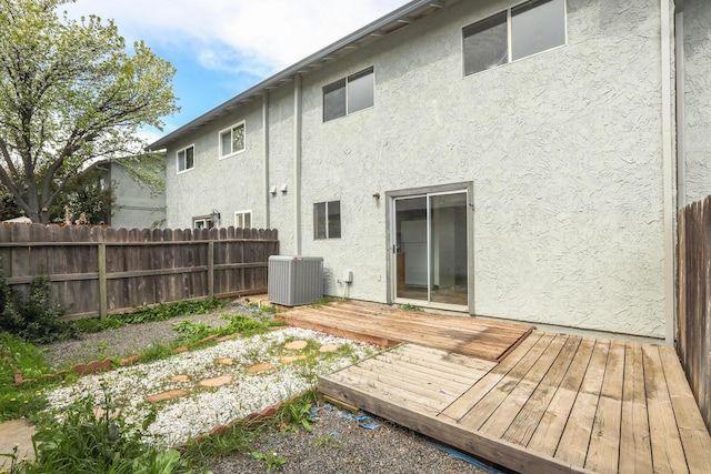 back of house with a deck, central AC unit, fence, and stucco siding