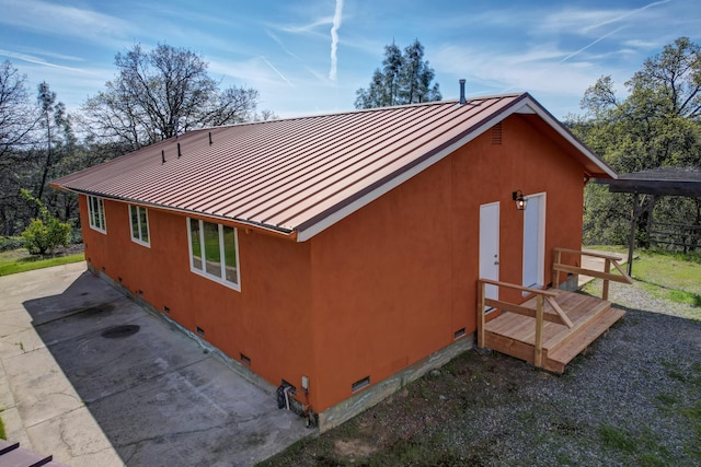 view of home's exterior with a standing seam roof, metal roof, and crawl space