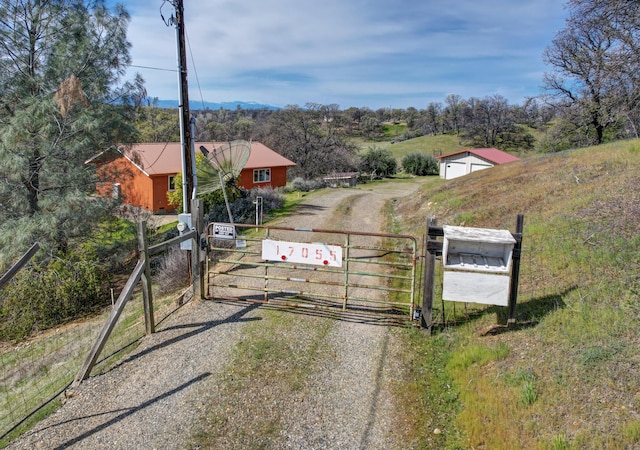 view of road with a gate, driveway, and a gated entry