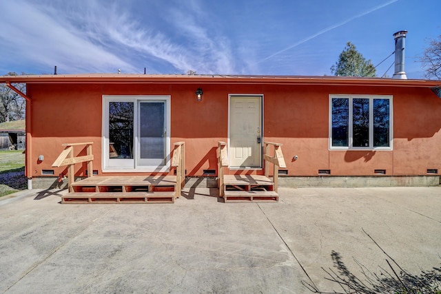 rear view of house featuring crawl space, a patio, stucco siding, and entry steps