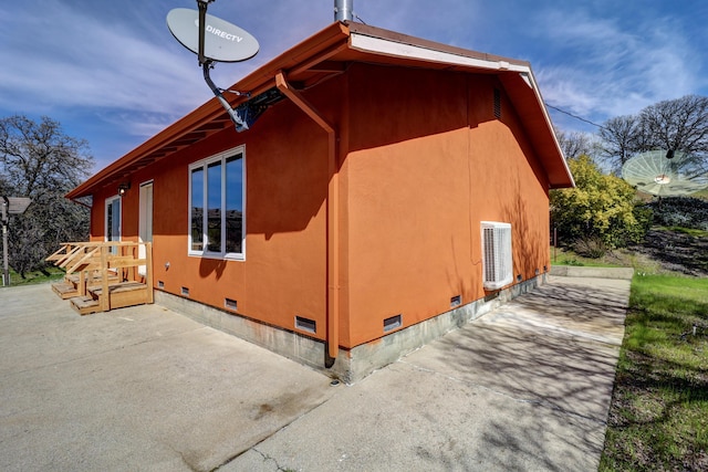 view of side of home featuring a patio area and crawl space