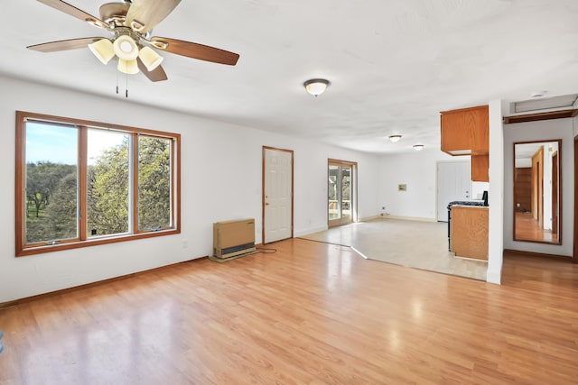 unfurnished living room with baseboards, a ceiling fan, and light wood-style floors