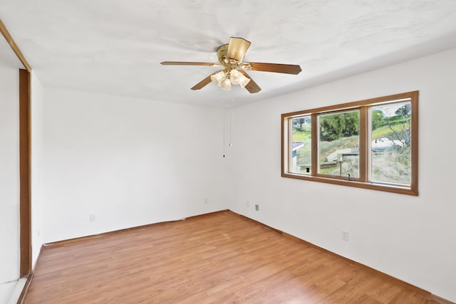 unfurnished room with a ceiling fan and light wood-style floors