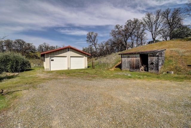 view of yard with a garage and an outbuilding