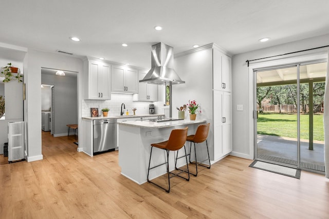 20190 Lupine Dr, Redding, CA 96002 - kitchen with island range hood, stainless steel dishwasher, a peninsula, backsplash, and white cabinets