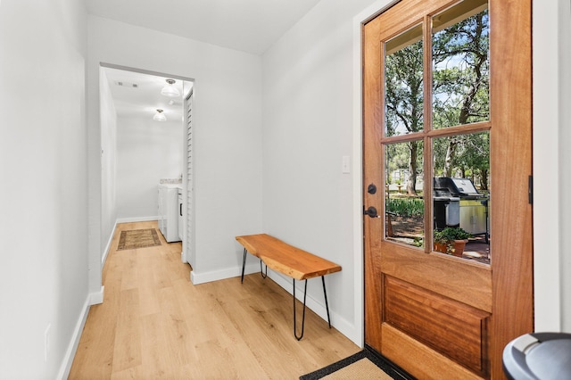 20190 Lupine Dr, Redding, CA 96002 - doorway to outside with washing machine and clothes dryer, light wood-style flooring, and baseboards