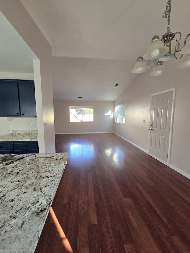 interior space with baseboards, a notable chandelier, dark wood-style flooring, and vaulted ceiling