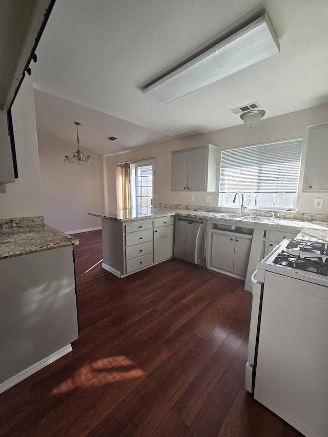 kitchen with visible vents, gas range gas stove, dark wood-style floors, a peninsula, and an inviting chandelier
