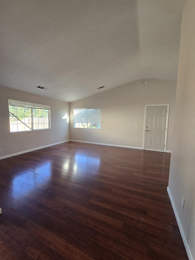 unfurnished room featuring dark wood-style floors, visible vents, and baseboards