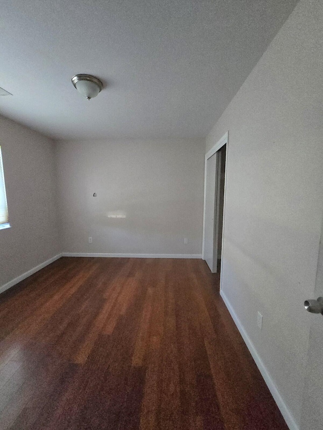 unfurnished room featuring baseboards and wood finished floors