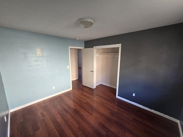 unfurnished bedroom with a closet, baseboards, and wood finished floors